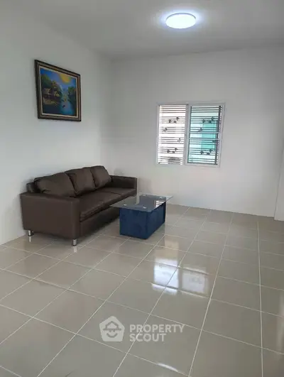 Spacious living room with modern sofa and coffee table, perfect for relaxation and entertainment.