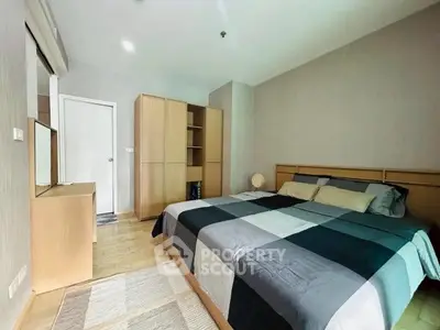 Spacious bedroom with modern decor and ample storage in a stylish apartment.