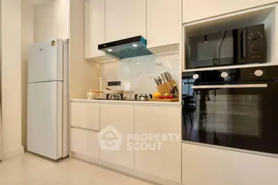 Modern kitchen with sleek white cabinetry, gas stove, and built-in oven for a stylish cooking experience.