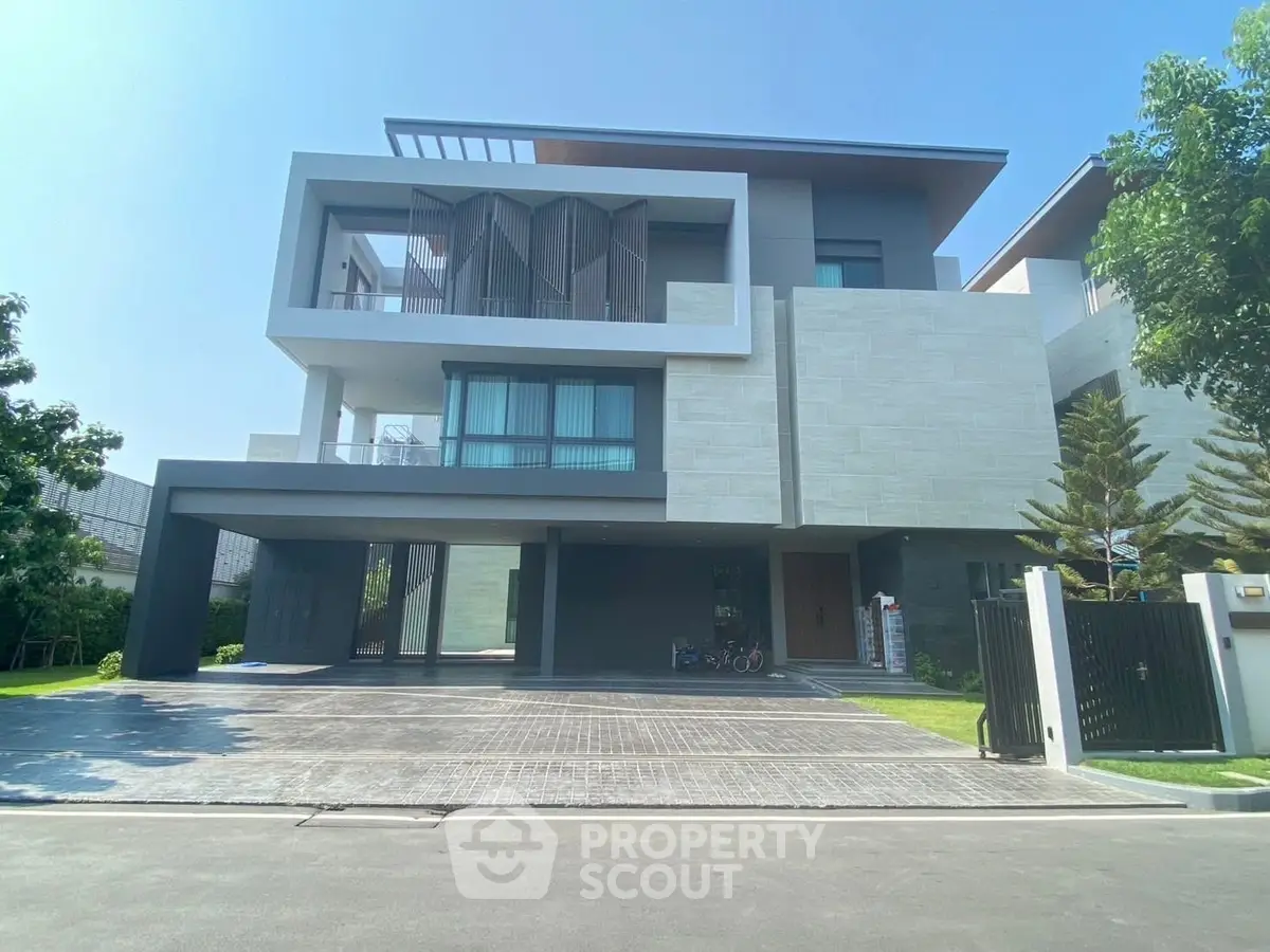 Modern luxury three-story house with sleek design and spacious driveway in a serene neighborhood.