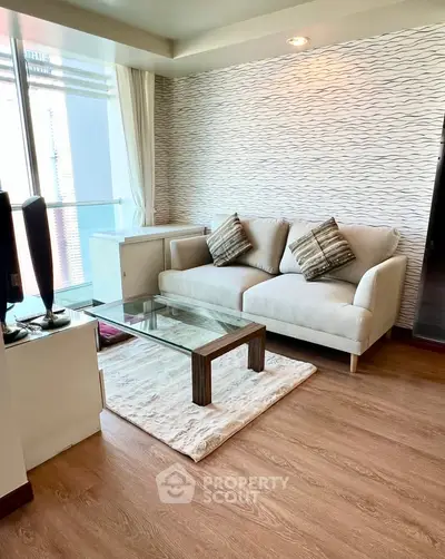 Modern living room with stylish sofa and glass coffee table in a cozy apartment setting.