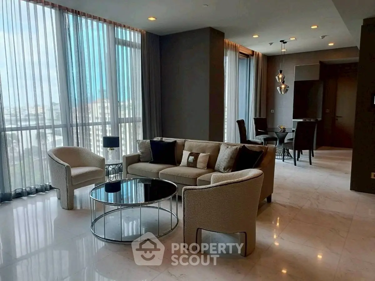 Luxurious living room with modern furniture and floor-to-ceiling windows offering stunning city views.