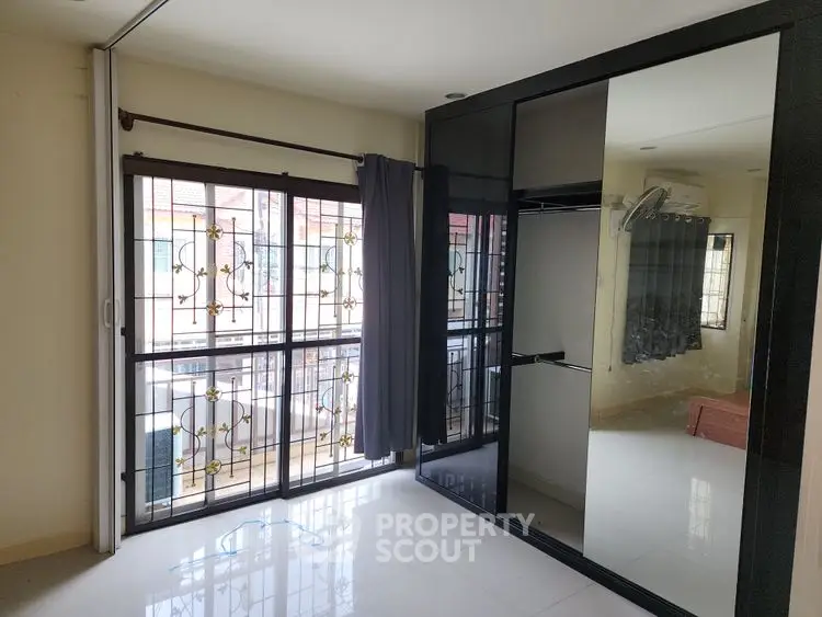 Spacious bedroom with large mirrored wardrobe and natural light