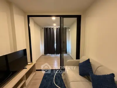 Modern living room with cozy sofa and TV, featuring a glass partition.