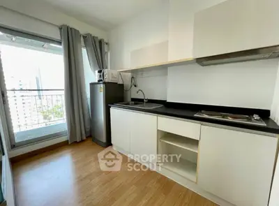 Modern kitchen with sleek cabinets and balcony view in urban apartment