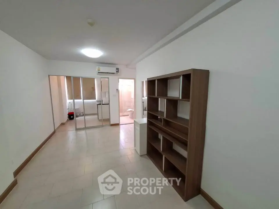 Spacious apartment interior with modern shelving and view into bathroom