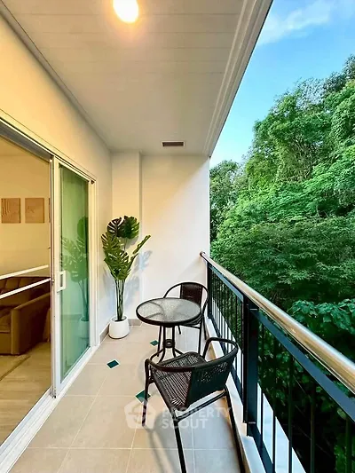 Charming balcony with lush green view, perfect for relaxation and outdoor dining.
