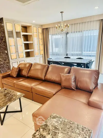 Luxurious living room with elegant leather sofa and chandelier, perfect for modern living.