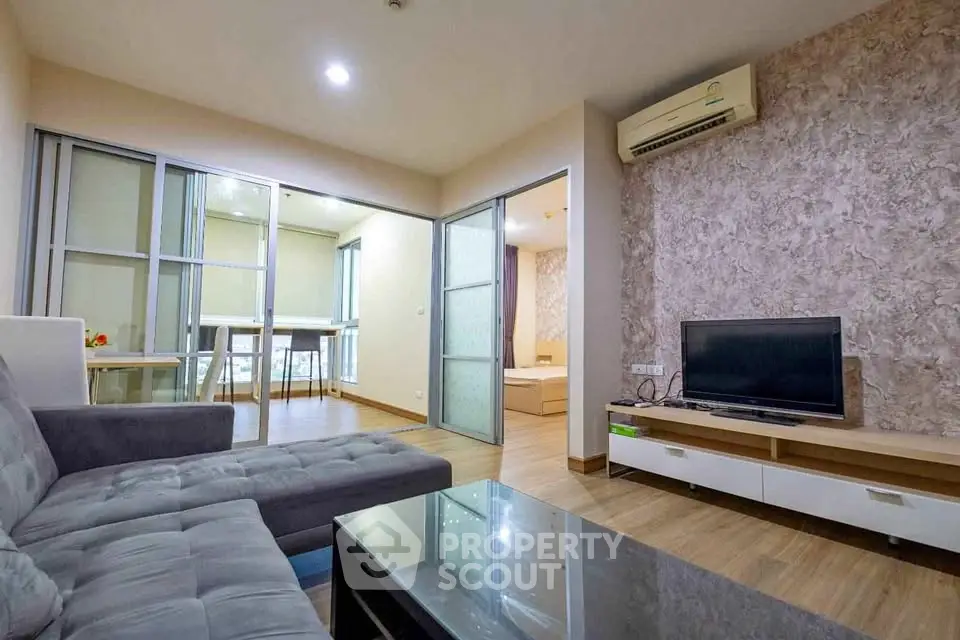 Modern living room with stylish decor and open layout, featuring a cozy sofa and sleek TV setup.