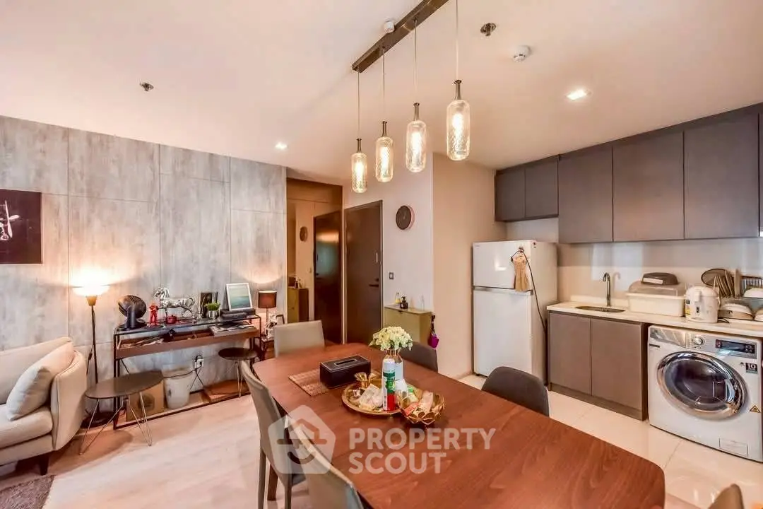 Modern open-plan kitchen and dining area with stylish lighting and appliances.