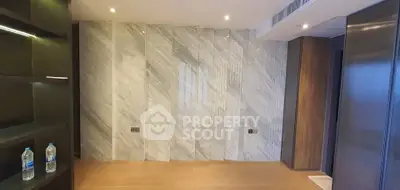 Luxurious modern interior with marble accent wall and wooden flooring