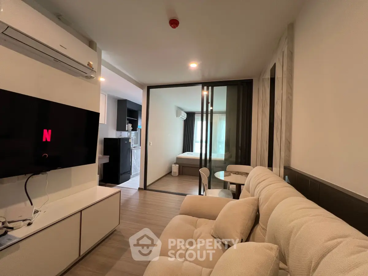 Modern living room with open layout and cozy furniture in a stylish apartment.