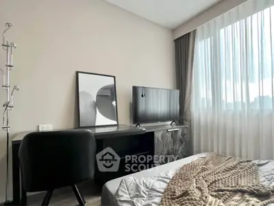 Modern bedroom with stylish decor, featuring a TV, desk, and large window with sheer curtains.