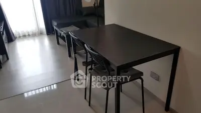 Modern minimalist living room with sleek black furniture and natural light.