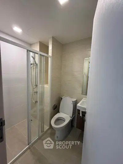 Modern bathroom with glass shower enclosure and sleek fixtures