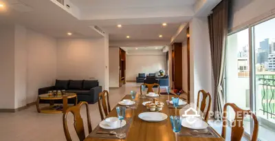 Spacious open-plan living and dining area with elegant wooden furniture and city view balcony.