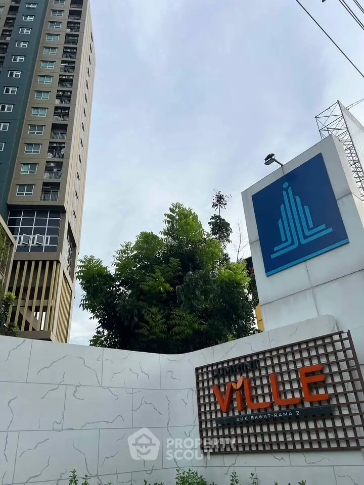 Modern high-rise building with distinctive signage and lush greenery