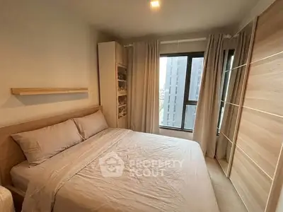 Cozy bedroom with large window and modern furnishings in a stylish apartment.