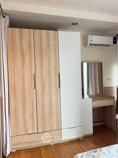 Spacious bedroom with modern wardrobe and air conditioning unit