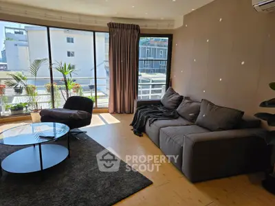 Spacious living room with large windows and cozy seating area