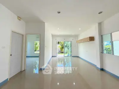 Spacious modern living room with large windows and glossy tiled floors
