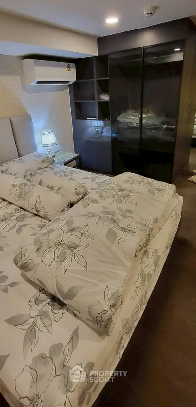 Cozy bedroom with floral bedding and sleek black wardrobe