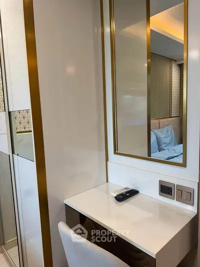 Modern bedroom with elegant vanity and mirror, featuring luxurious decor and ambient lighting.