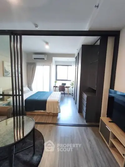 Modern studio apartment with sliding glass doors, cozy bedroom, and stylish living area.