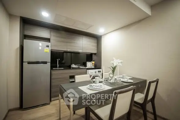 Modern kitchen with dining area featuring sleek appliances and elegant table setting.