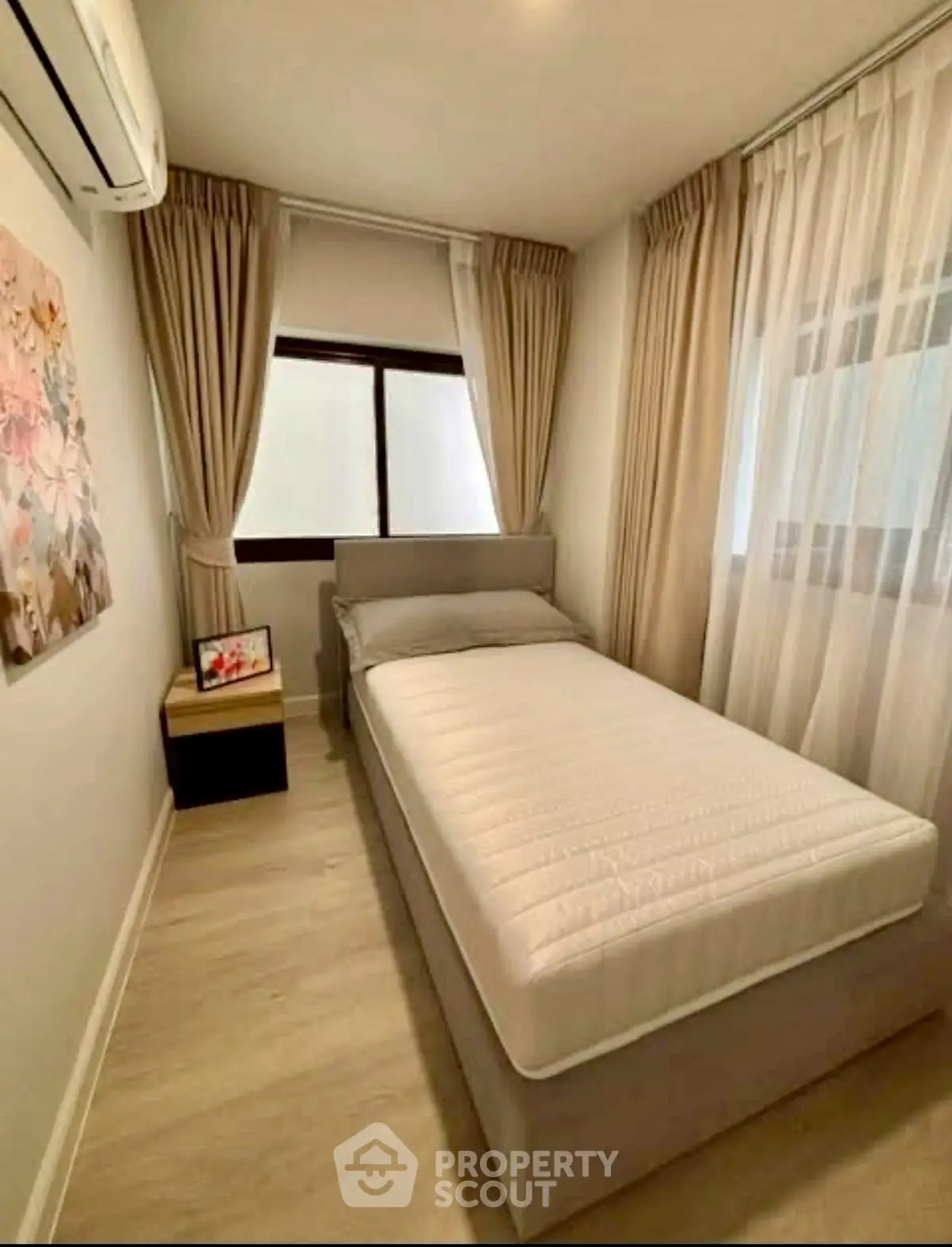 Cozy bedroom with single bed, elegant curtains, and soft lighting.