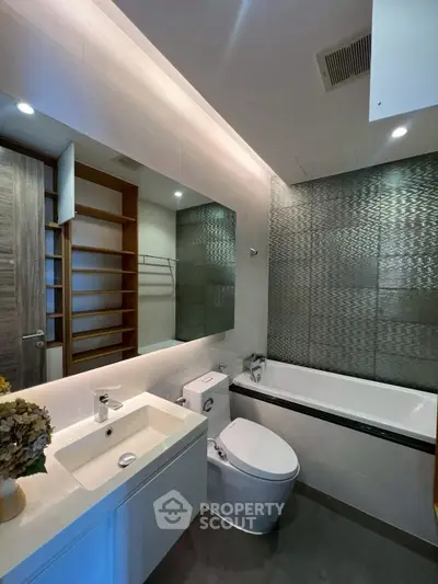 Modern bathroom with sleek design, featuring a bathtub and stylish fixtures.