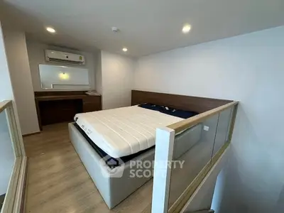 Modern bedroom with elevated bed and sleek wooden flooring in a stylish apartment.