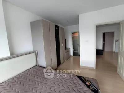 Spacious bedroom with modern wardrobe and ensuite bathroom in a stylish apartment.