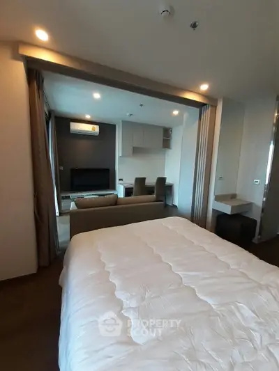 Modern open-layout bedroom with cozy living area and stylish decor