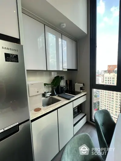 Modern kitchen with sleek cabinetry and city view from window