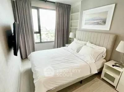Modern bedroom with city view, featuring elegant decor and ample natural light.