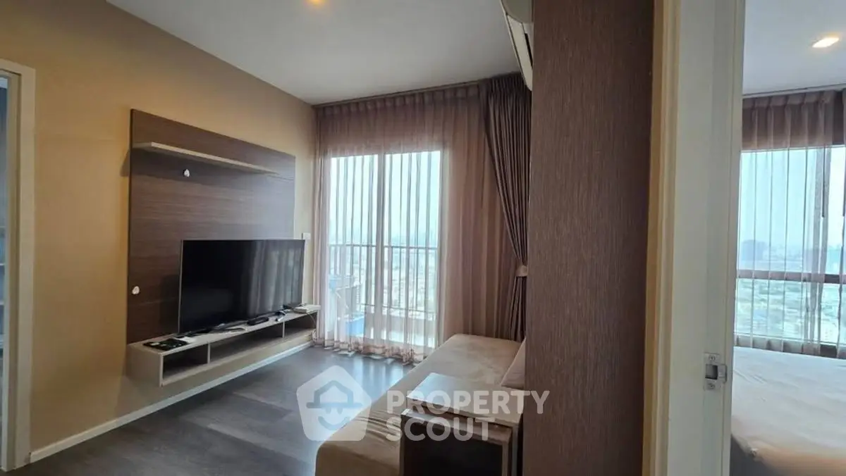 Modern living room with TV and large windows offering city views