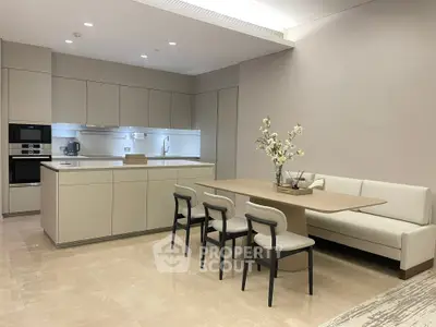 Modern kitchen with sleek cabinetry and dining area featuring elegant seating