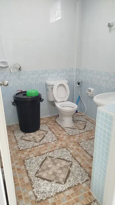 Compact bathroom with tiled floor and basic fixtures, ideal for budget-friendly homes.