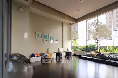 Spacious modern living room with floor-to-ceiling windows and urban view.