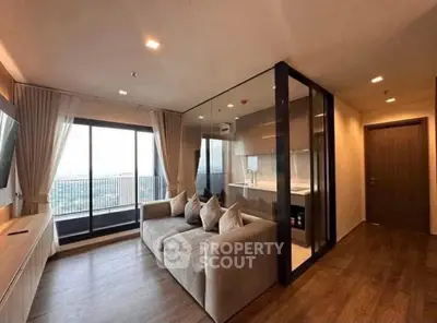 Modern living room with glass partition and balcony view in a stylish apartment.