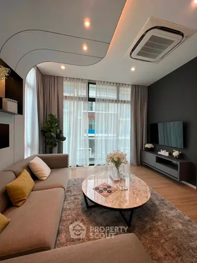 Modern living room with stylish decor, large windows, and cozy seating area.