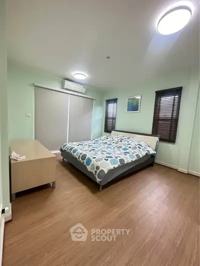 Spacious bedroom with modern decor and large windows for natural light