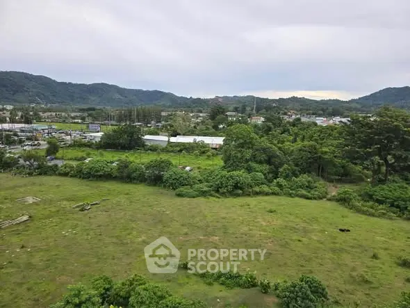 Scenic view of lush green landscape with distant hills, perfect for real estate development.