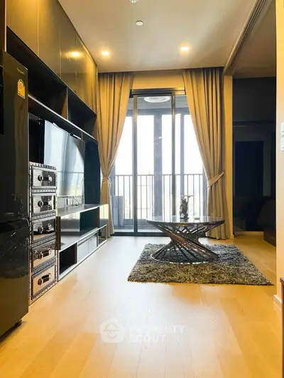 Modern living room with sleek furniture and large windows leading to a balcony.