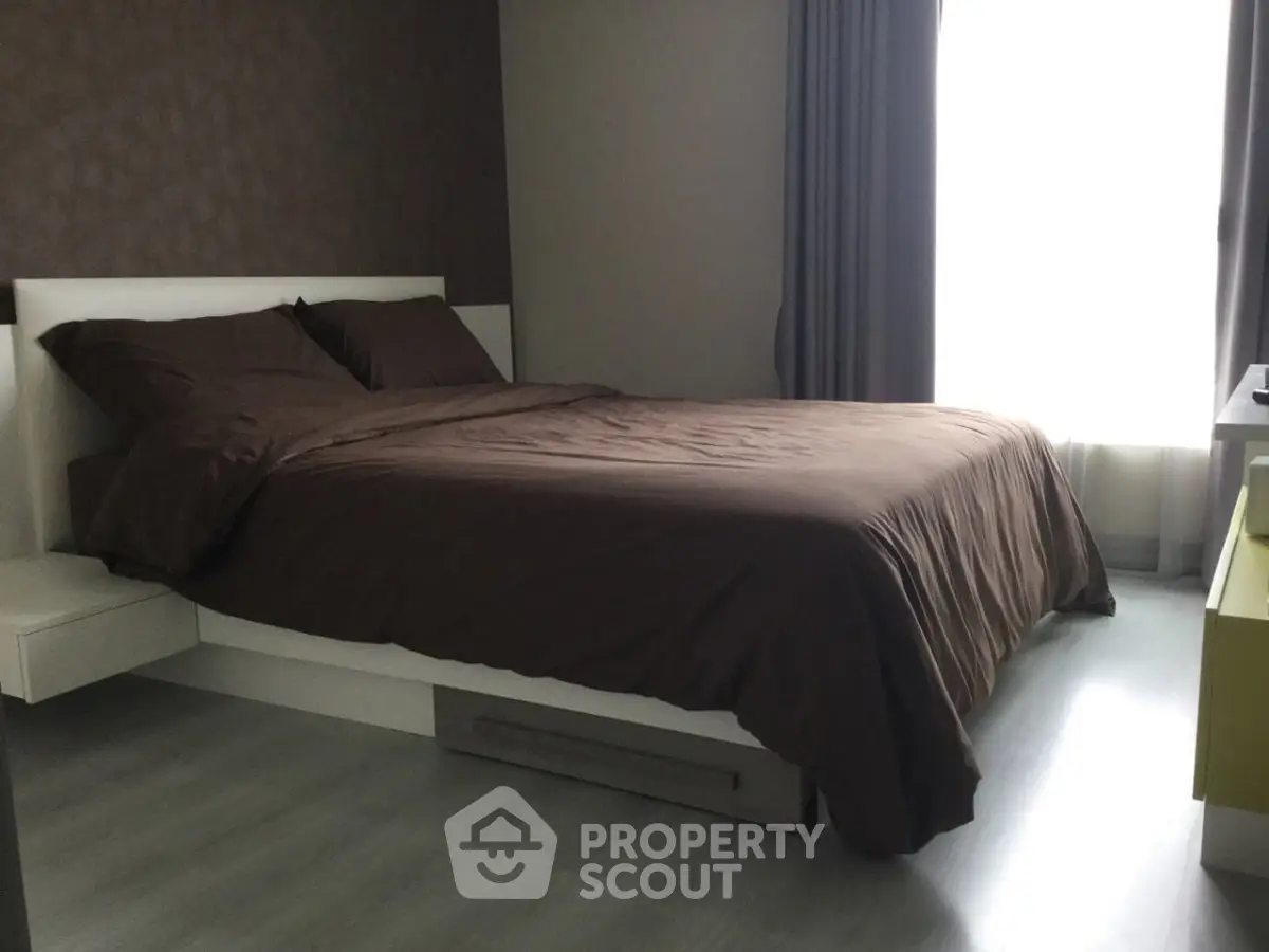 Modern bedroom with sleek design and natural light, featuring a comfortable bed and stylish decor.