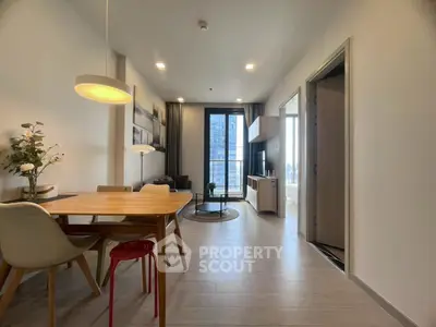 Modern living room with dining area and city view, featuring stylish furniture and natural light.