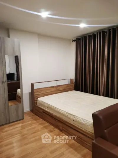 Modern bedroom with wooden flooring and stylish furniture in a cozy apartment.