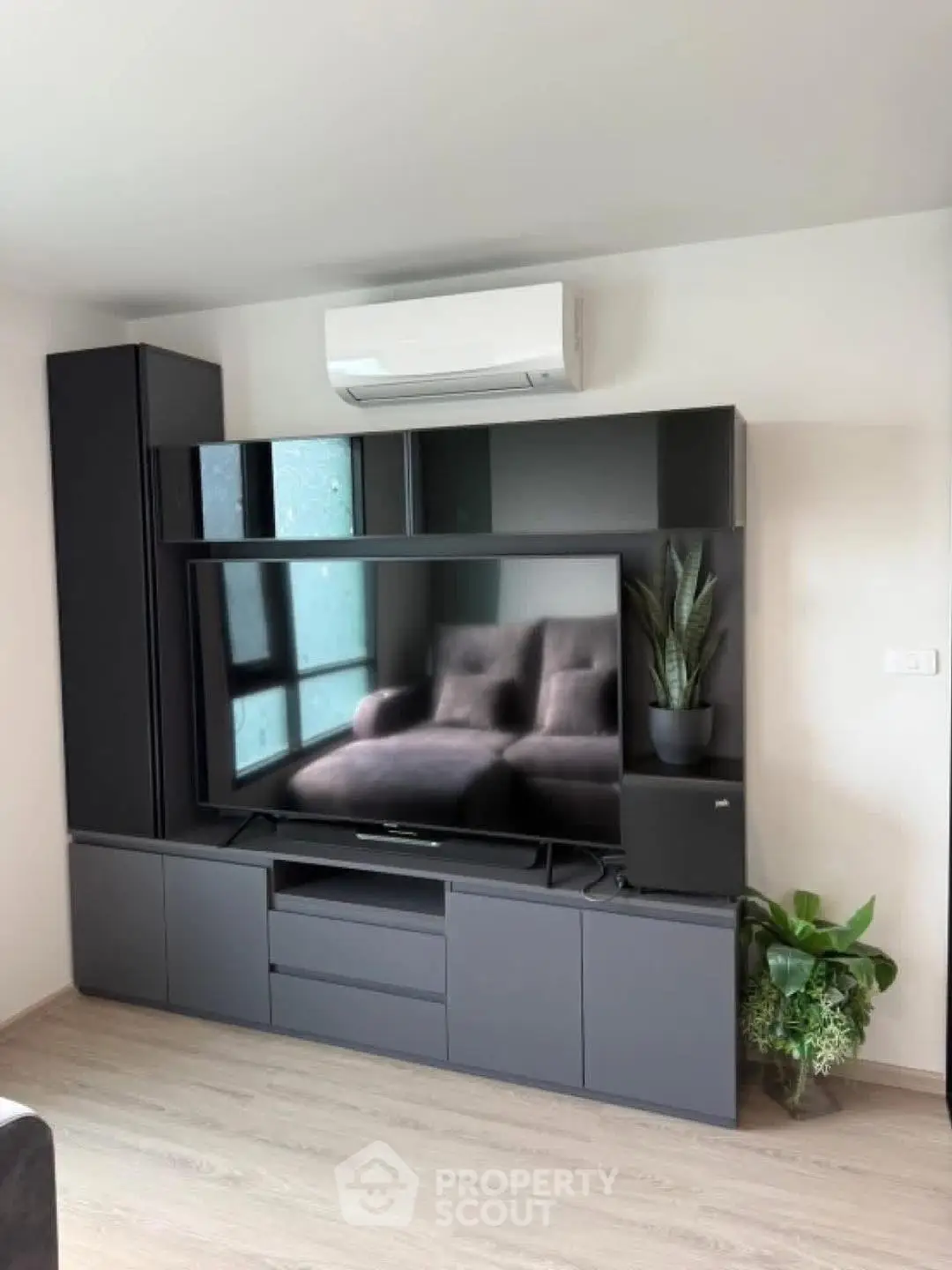 Modern living room with sleek entertainment unit and air conditioning