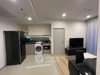 Modern open-plan kitchen and living area with sleek appliances and stylish decor.